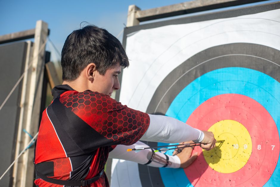 Focused young archer hitting the bullseye with precision outdoors.