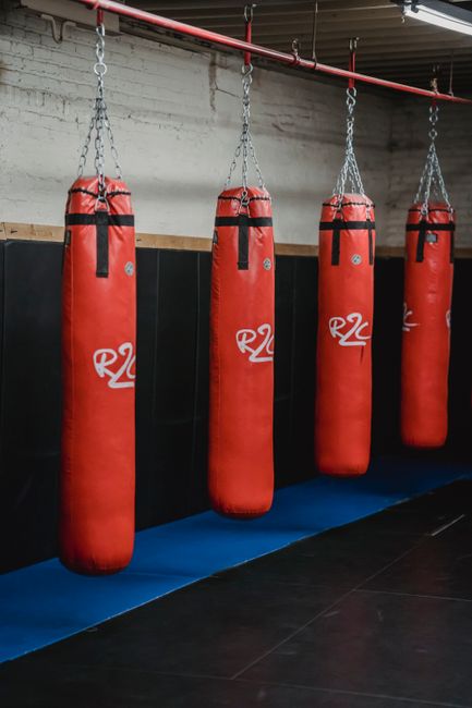 Interior of boxing gym with heavy punching bags hanging on chains for workout