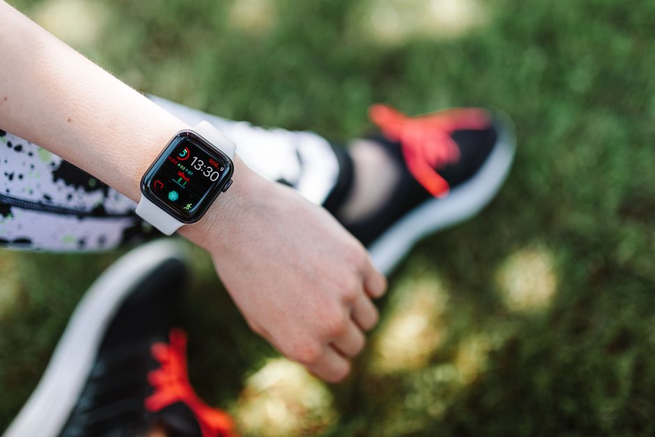 Close-up of a smartwatch on a woman's wrist during outdoor fitness activity.
