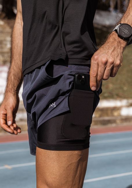 Athletic man with smartphone in pocket wearing sportswear on a sunny day