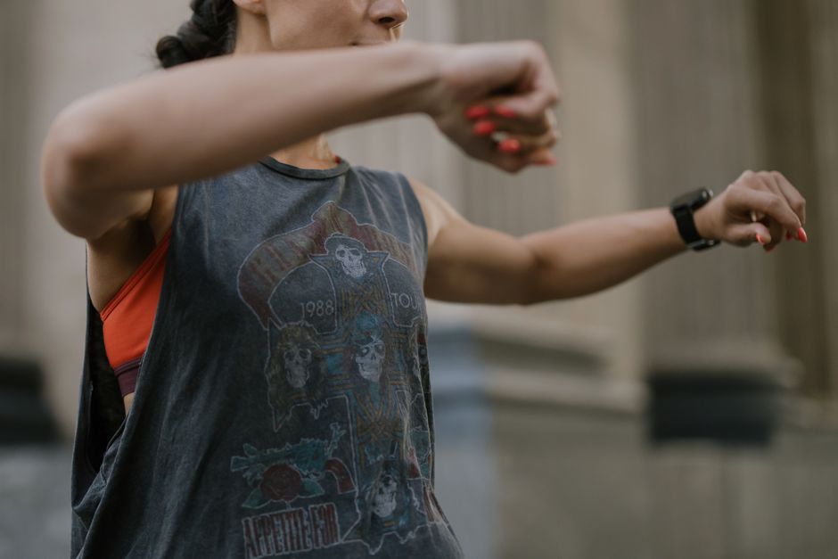 A woman in a tank top works out energetically outdoors, capturing a fit lifestyle.