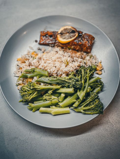 Delicious meal featuring grilled salmon, seasoned rice, and steamed broccoli.