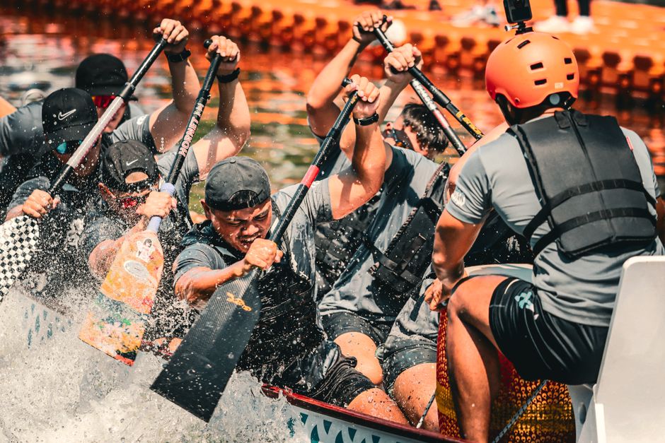 Energetic dragon boat team in synchronized paddling during a competitive race.