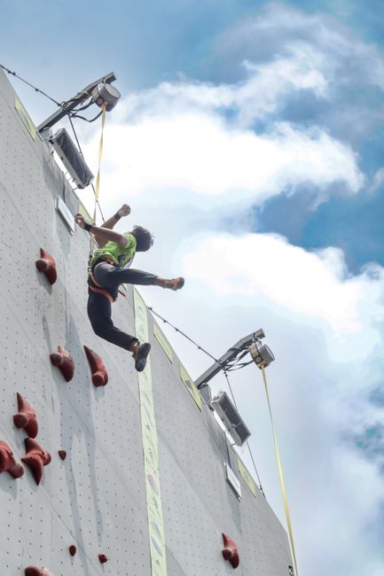 A thrilling scene of a person climbing a challenging rock wall outdoors.