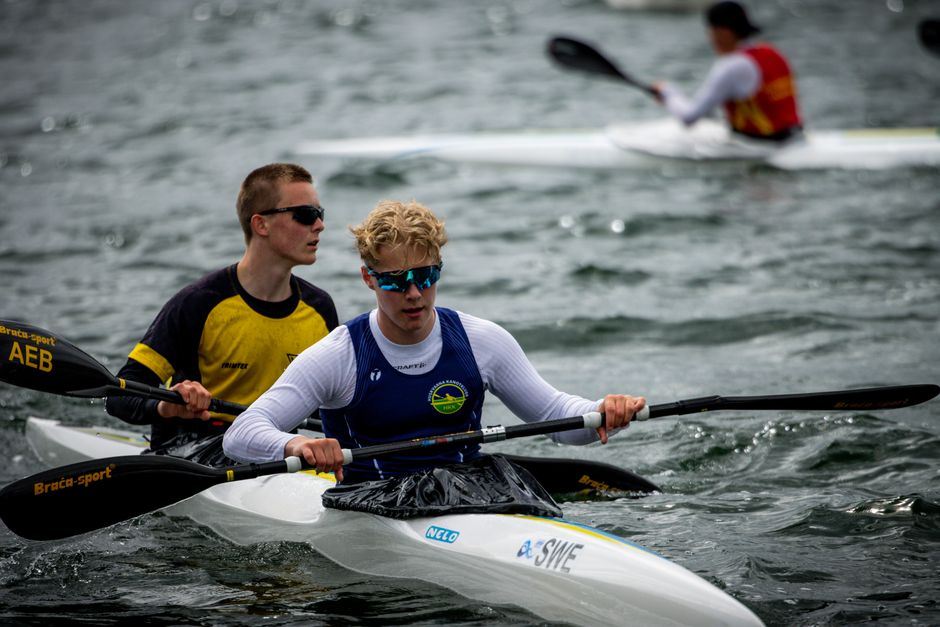 Intense kayaking competition on a wavy Swedish waterway, showcasing skill and determination.