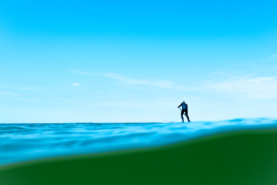 A paddleboarder enjoys a sunny day on the Baltic Sea near Rostock, Germany.