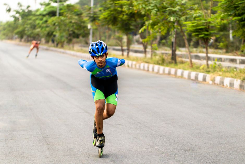 Young skaters racing down a road in Surat, India, showcasing athletic energy.