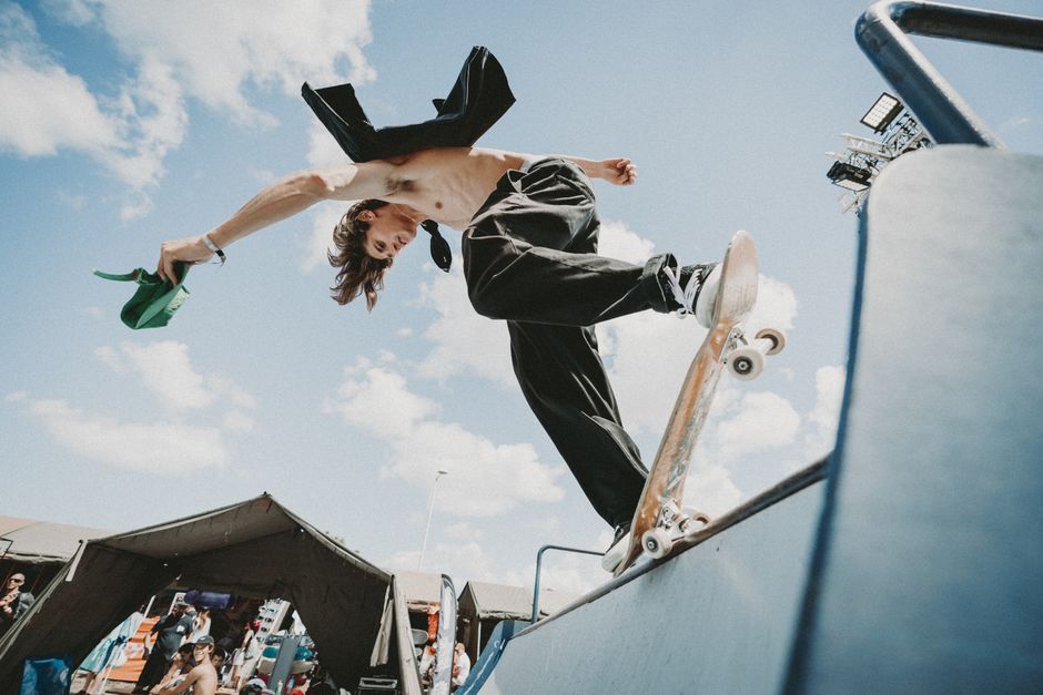 Dynamic shot of a skateboarder executing a trick on a ramp at an urban skate park.