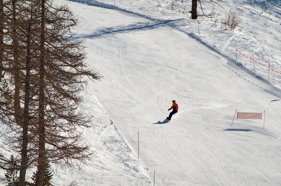 A snowboarder enjoying a sunny day on a snow-covered slope, showcasing winter sports excitement.