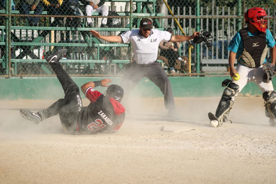 Exciting play at home plate during a baseball game with players and an umpire.