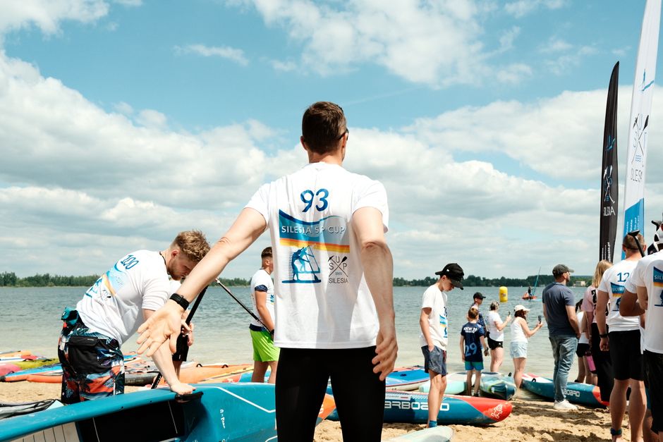 Group of people participating in a SUP Cup event at the beach.