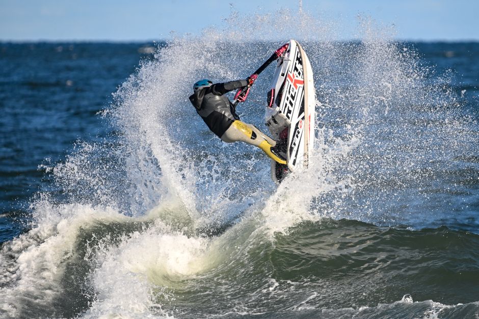 Dramatic jet skiing action in Narragansett, Rhode Island, capturing a rider mid-air over ocean waves.