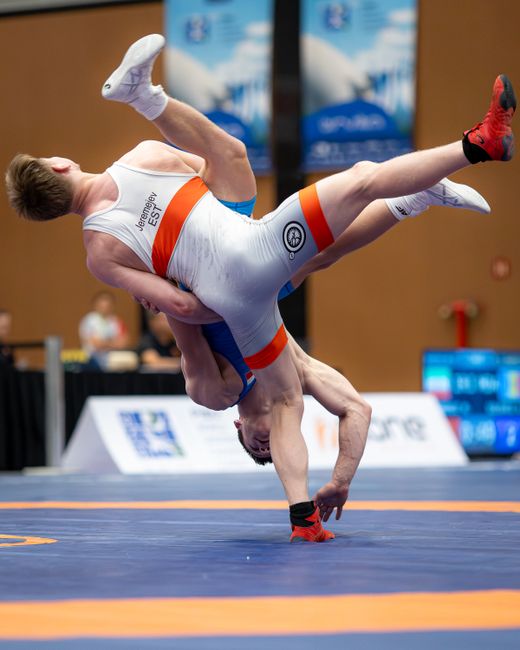 Vibrant action shot of wrestlers competing, showcasing athletic skill and intense competition.