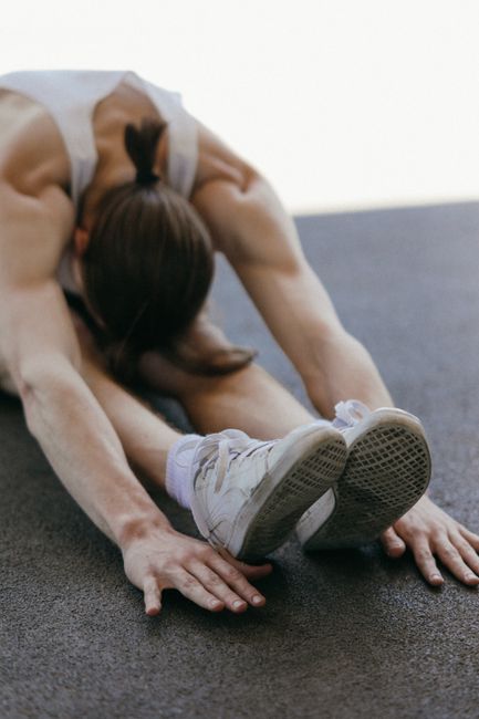 A man performing a stretch on a gym floor, emphasizing fitness and flexibility.