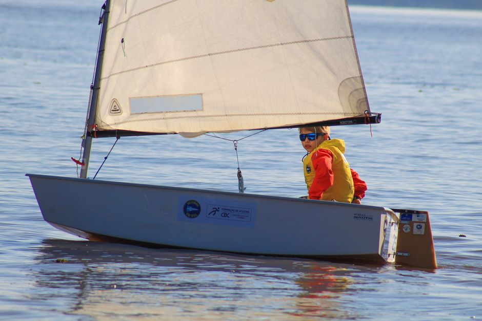 A child sails solo on a small boat enjoying a sunny day on the ocean.